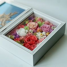 two white boxes filled with flowers on top of a table