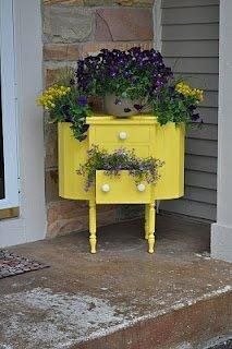 a yellow dresser with flowers on it sitting in front of a door and some steps