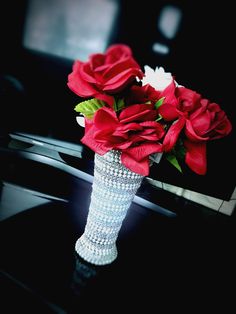 a vase filled with red roses on top of a table