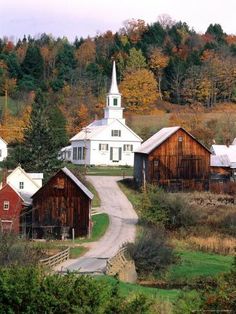 an old country road leads to several small white buildings