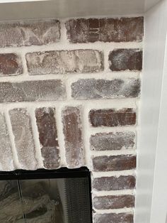 a brick fireplace with a mirror on the mantle