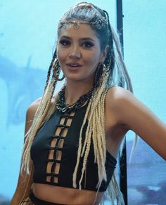 a woman with dreadlocks standing in front of a screen