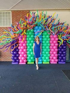 a woman standing in front of a bunch of balloons