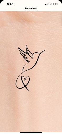 a small tattoo on the back of a woman's stomach with a bird flying over it