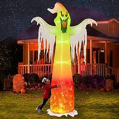 a man standing in front of a lighted halloween ghost on top of a green field