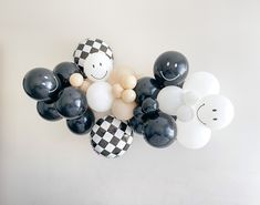 black and white balloons are arranged on the wall