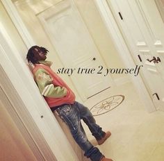 a man leaning against a wall with the words stay true 2 yourself