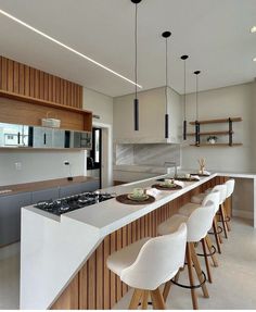 a kitchen with white counter tops and bar stools