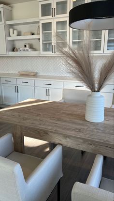 a wooden table with white chairs around it