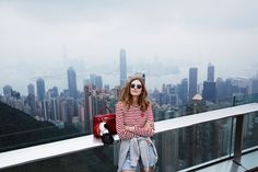 a woman standing on top of a tall building