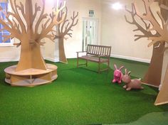 an indoor play area with fake trees and benches