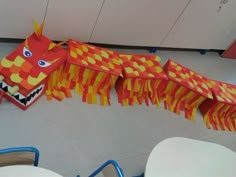 an orange and yellow dragon kite sitting on the floor