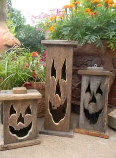 two wooden vases sitting next to each other on top of a stone floor in front of potted plants