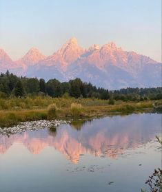 the mountains are reflected in the still water