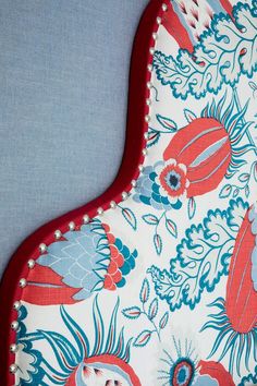 an oven mitt covered in red and blue fabric with floral designs on it's sides