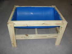 a wooden table with a blue plastic pool in it's center and legs on the floor