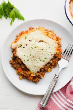 a white plate topped with mashed potatoes and meat