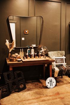 a room with a mirror, stool and table in it that has various items on it