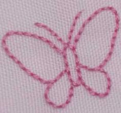 a close up of a piece of cloth with pink thread on it and a butterfly shaped object in the middle