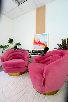 two pink chairs sitting in front of a tv on top of a white carpeted floor