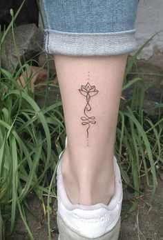 a woman's foot with a small flower tattoo on the left side of her leg