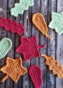 several crocheted hearts are arranged on a wooden surface, with one heart in the middle