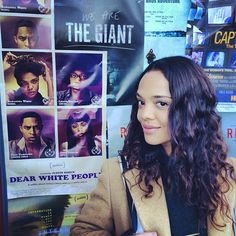 a woman standing in front of a movie poster