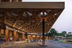 the entrance to royal club beach resort and spa is lit up at night with people walking around