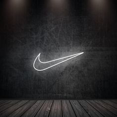 the nike logo is lit up against a dark wall with three spotlights on it