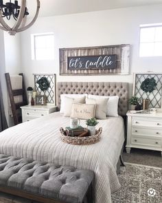 an instagram photo of a bedroom with white furniture and gray bedding, including a chandelier