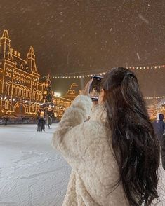 a woman taking a photo with her cell phone in the snow