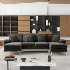 a living room filled with lots of furniture and bookshelves on the wall next to a coffee table