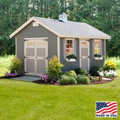 a small gray shed sitting in the grass