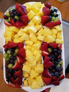 a platter filled with fruit and cheese on top of a table