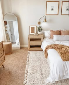 a bed room with a neatly made bed next to a dresser and mirror on the wall