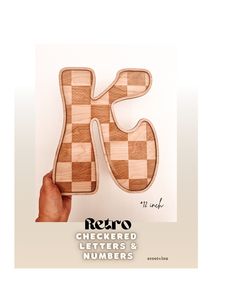 the letter k is made out of wood and has a checkerboard pattern on it