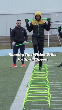 a man is running on a track with two green handles