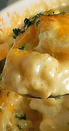 a close up of a spoon full of chicken and cheese casserole with broccoli