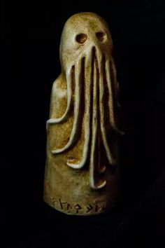 a ceramic figurine with an octopus head on it's face and hands