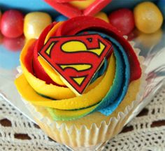 cupcakes decorated with superman logo on top of each other in plastic wrappers