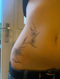 a woman's stomach with a flower tattoo on her belly and the bottom part of her lower body