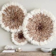 three brown and white circular rugs hanging on the wall above a fireplace mantel