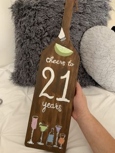 a wooden sign that says cheers to 21 years