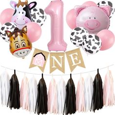 an animal themed 1st birthday party with balloons and streamers, including one balloon in the shape of a cow