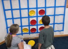 two children are playing with an interactive game on the floor in front of a wall