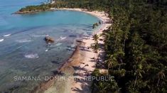 an aerial view of the beach and ocean with palm trees in the foreground, surrounded by blue water