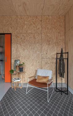 a room with an orange wall and a white chair