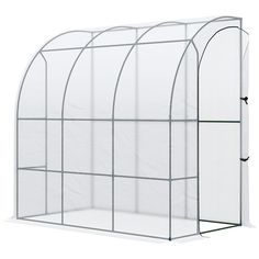 a large white greenhouse with the door open and mesh covering on it's sides