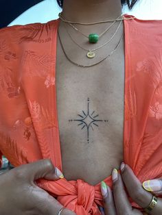 a woman with tattoos on her chest holding onto a piece of string that is attached to her chest