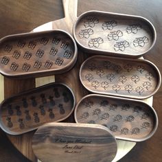 six wooden trays with designs on them